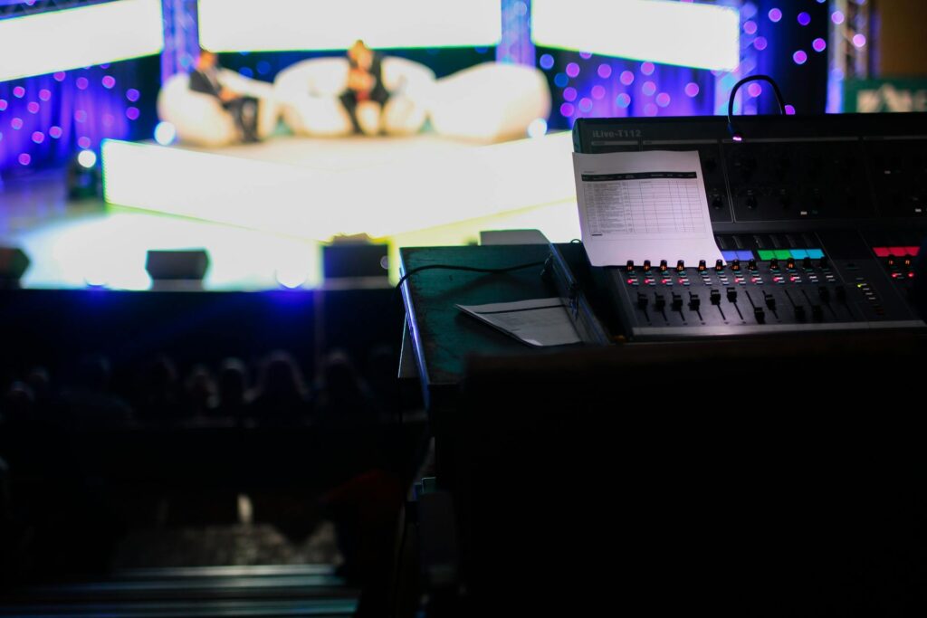 Audio engineer’s soundboard in the control booth during a tech rehearsal for a live event.