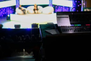 Audio engineer’s soundboard in the control booth during a tech rehearsal for a live event.
