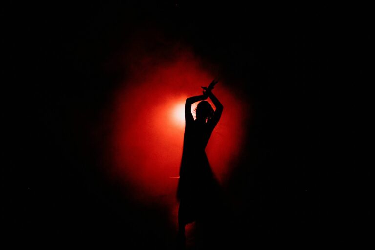 Silhouetted dancer in red uplighting provided by WestWave AV event lighting rentals.