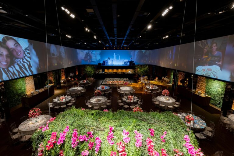 Large indoor event space with stage, banquet tables, and floral decor, professionally equipped with audio rentals for live entertainment.