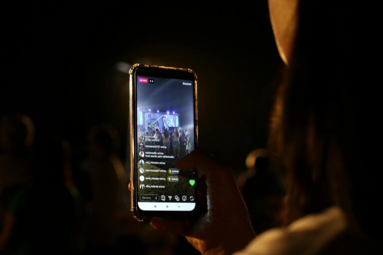 Person live streaming an event from their phone with WestWave AV providing live streaming services in the background.