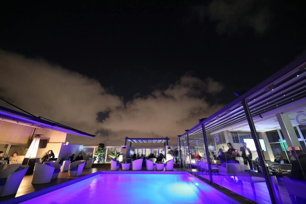 Ambient poolside setting with atmospheric lighting to host a networking event