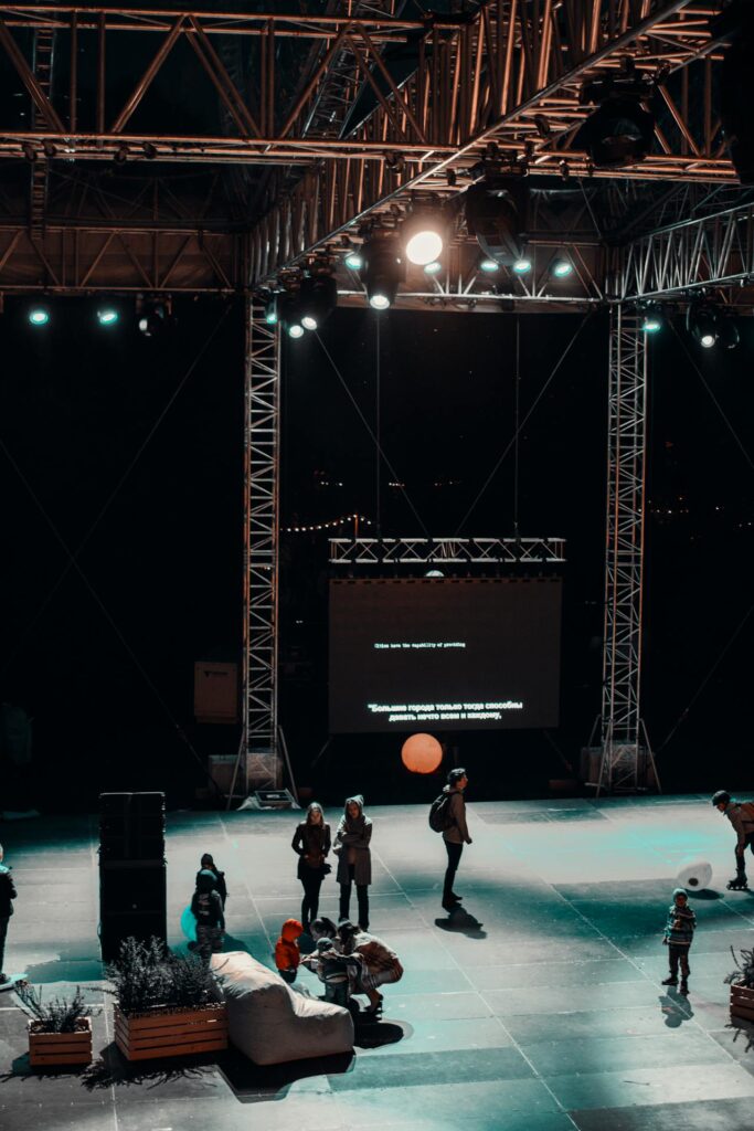 Professional AV event space with stage lighting and sound setup, showing why planners should book your event AV early